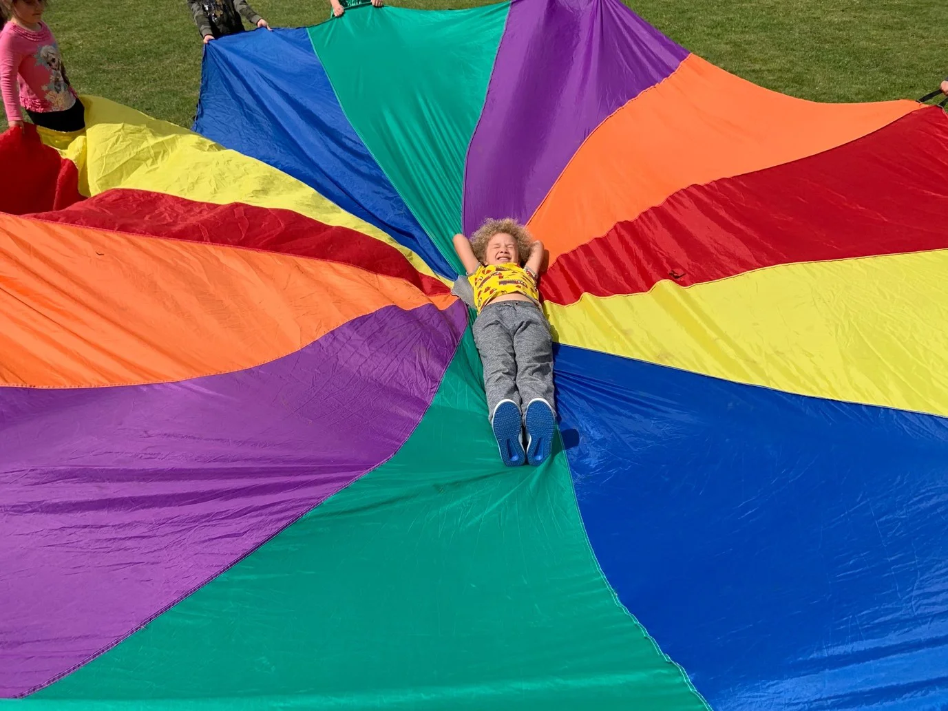 A child lying on a multi-coloured sheet