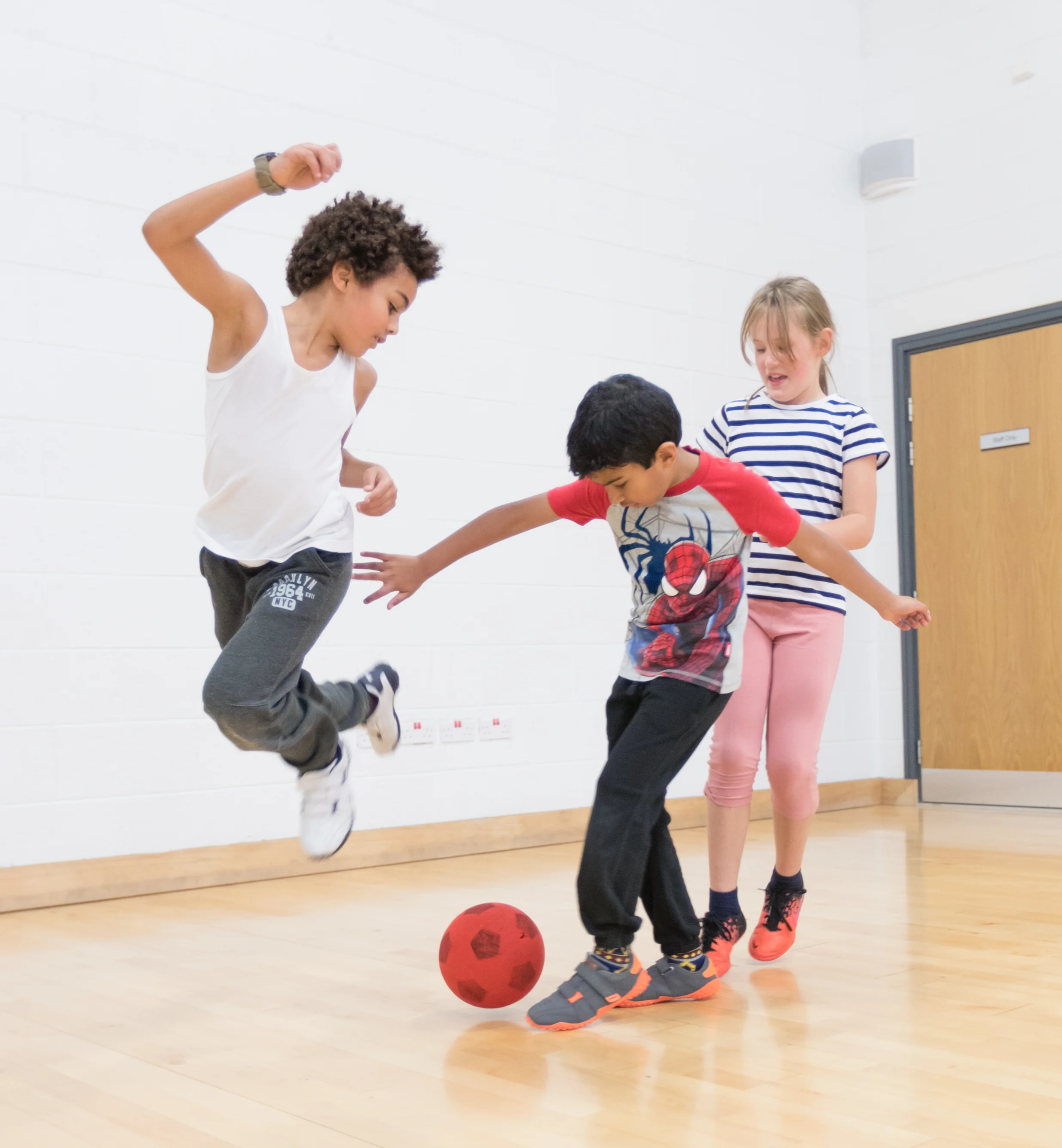 Children playing football indoors